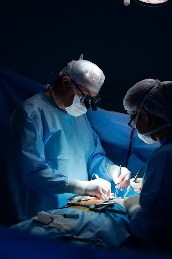 Medical professionals performing surgery in a sterile operating room.