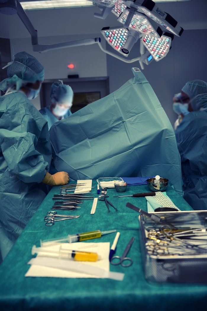 A team of surgeons in an operating room using various surgical instruments.